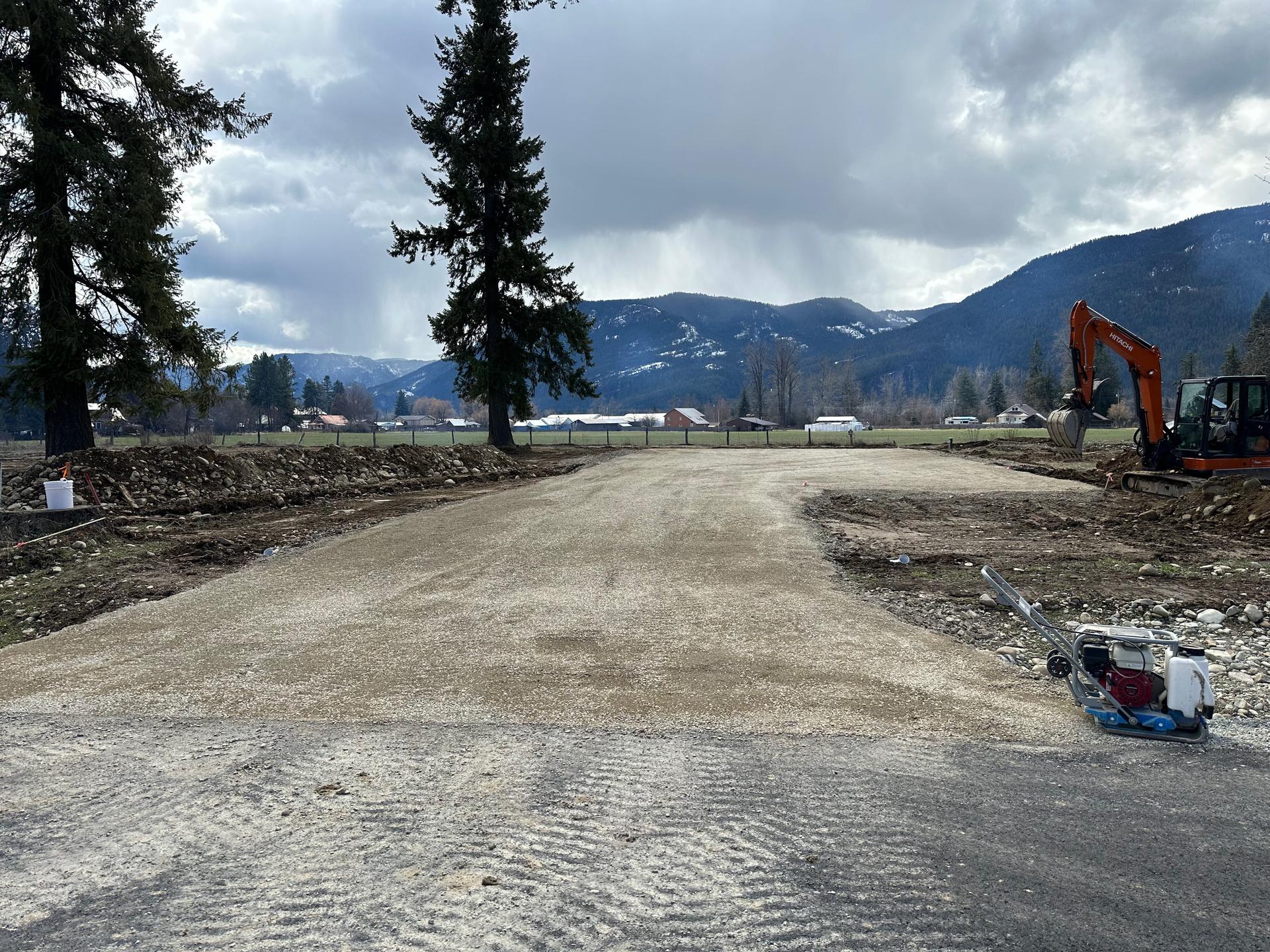 Finished gravel road with lake and mountain backdrop
