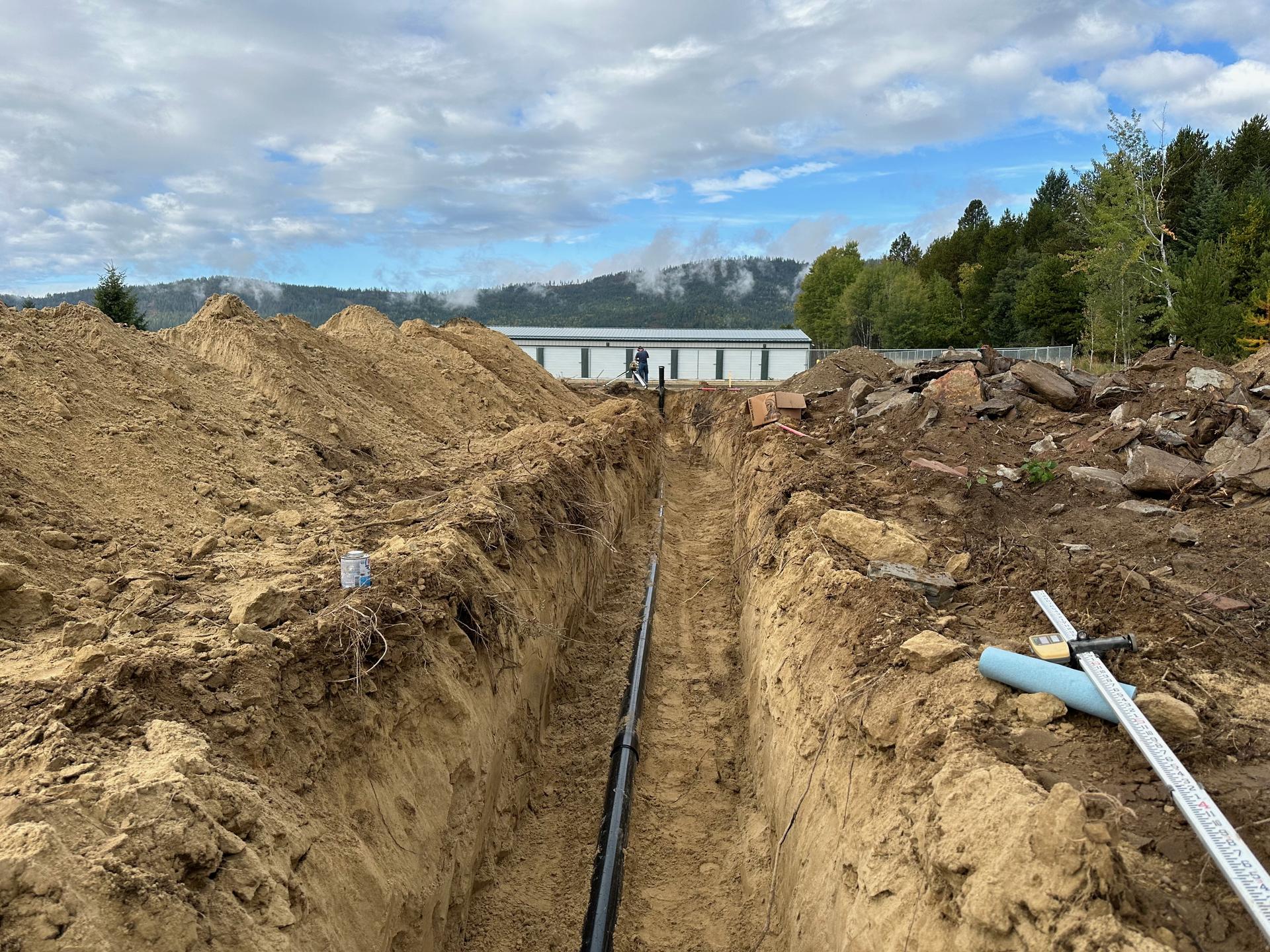 Premier Land Service septic trench excavation near Sandpoint bridge with pipe installed