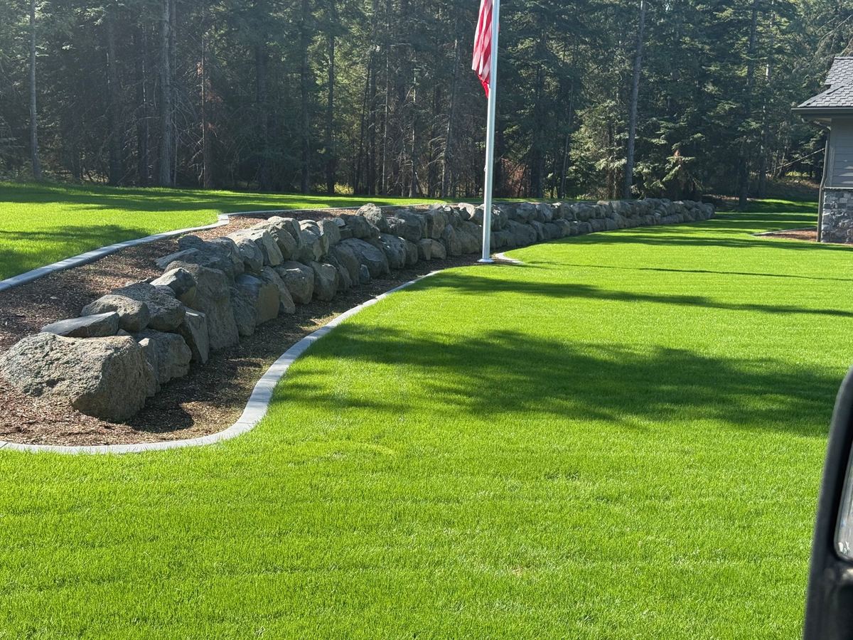 3-ft basalt boulder retaining wall with custom rock steps on an Athol, Idaho luxury home