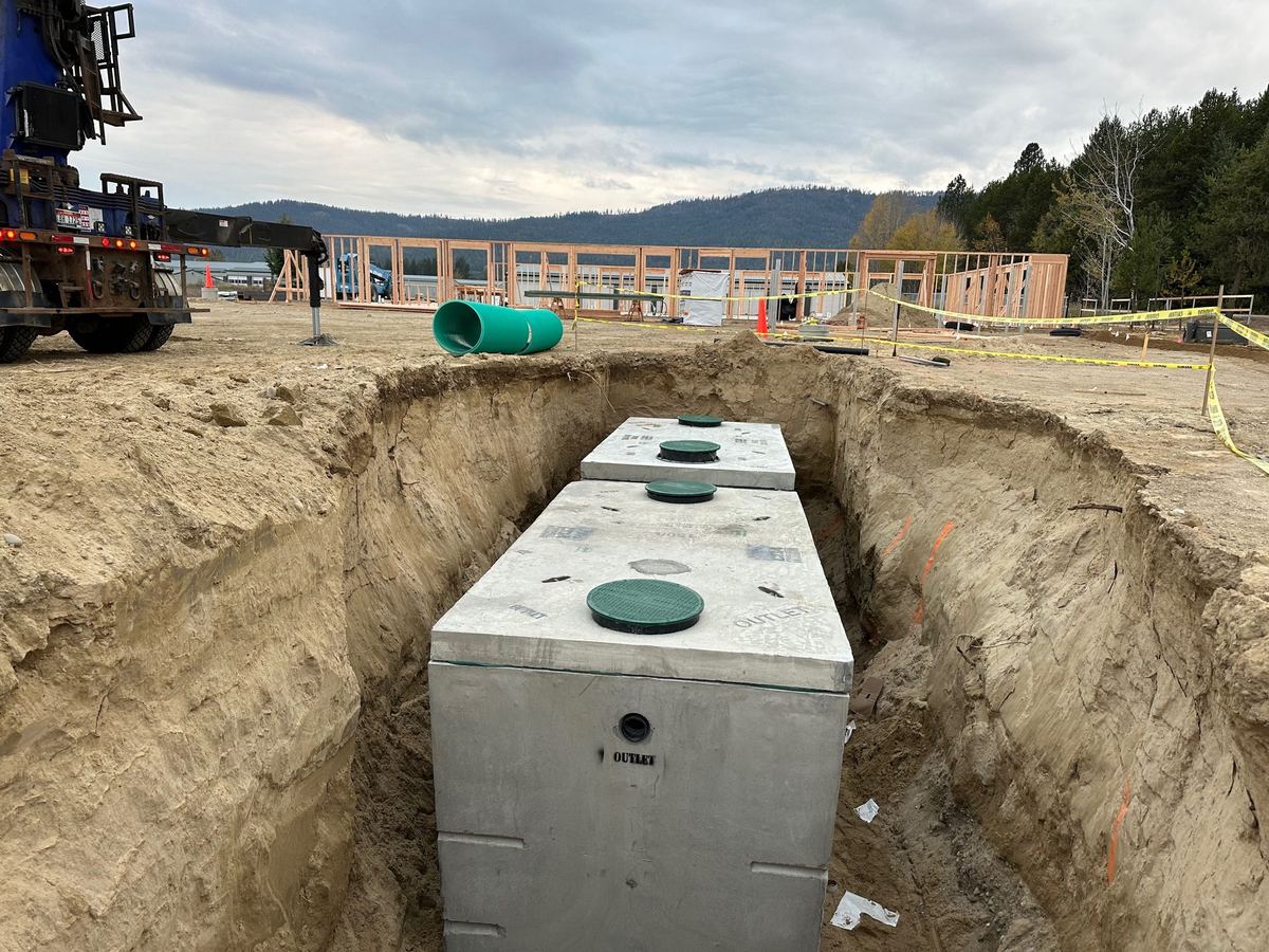 Large excavated pit with concrete tanks in place at a commercial Premier Land Service jobsite