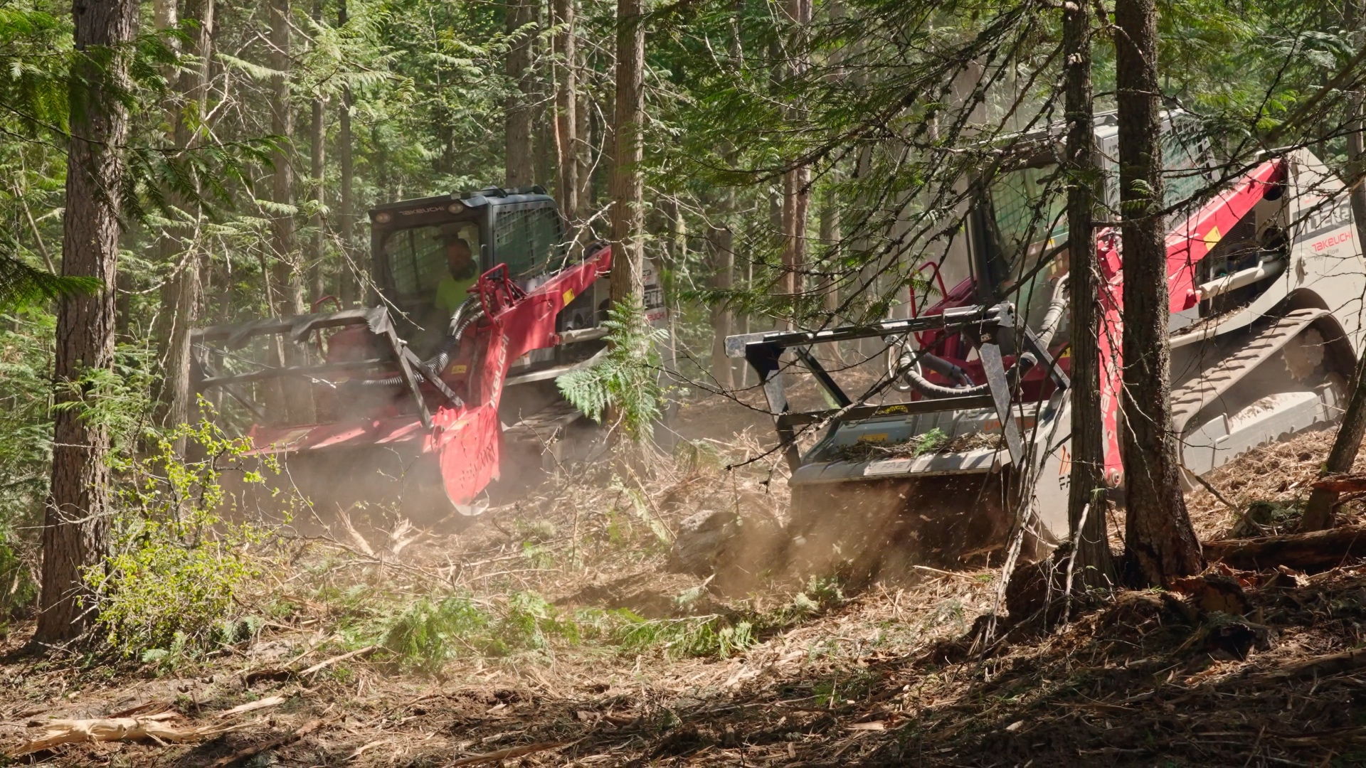 Two Premier Land Service forestry mulchers actively clearing a North Idaho parcel